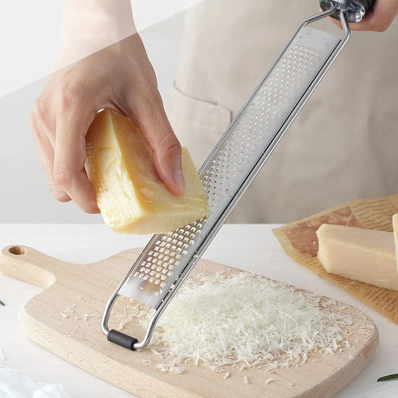 A versatile Cheese Grater featuring multiple grating surfaces for fine, medium, and coarse textures. Made from durable stainless steel with an ergonomic handle for comfortable use. Compact design with a hanging loop for easy storage. Ideal for grating cheese and vegetables in any kitchen setting.