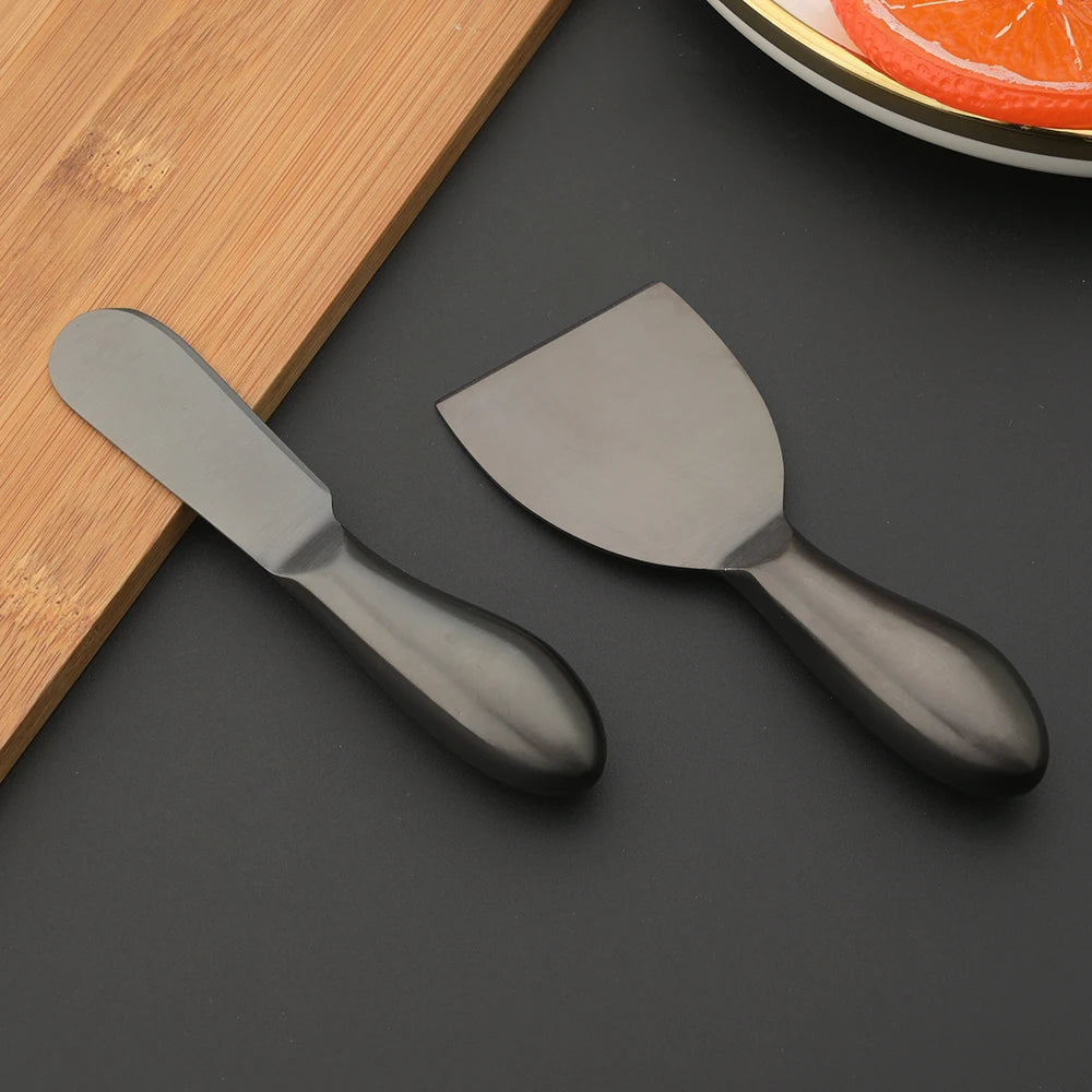 A premium Cheese Utensils Set featuring a pronged knife for semi-soft cheeses, a thin knife for slicing soft cheeses, a heart knife for cutting hard cheeses, a serving knife for elegant serving, a chisel knife for breaking crumbly cheeses, and a spreader knife for soft cheeses and pâtés. Crafted from high-quality stainless steel with ergonomic handles, these durable and easy-to-clean utensils add sophistication to any cheese platter.