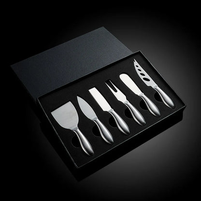 A premium Cheese Utensils Set featuring a pronged knife for semi-soft cheeses, a thin knife for slicing soft cheeses, a heart knife for cutting hard cheeses, a serving knife for elegant serving, a chisel knife for breaking crumbly cheeses, and a spreader knife for soft cheeses and pâtés. Crafted from high-quality stainless steel with ergonomic handles, these durable and easy-to-clean utensils add sophistication to any cheese platter.